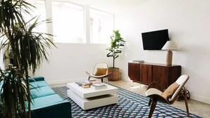 Ett modernt vardagsrum med en soffa, ett soffbord och en tv.