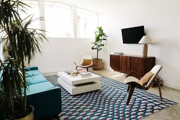 A modern living room with a sofa, coffee table, and a TV. - Refreshing Pool/Backyard Desert Oasis (Phoenix)