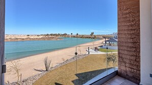Un balcon avec vue sur une plage et une rivière.