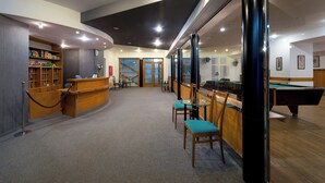 A billiards room with a pool table, chairs, and a reception desk. - Hotel Bohemia (Zelezna Ruda)