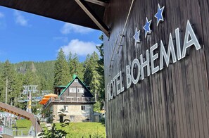 A wooden building with a sign reading "HOTEL BOHEMIA". - Hotel Bohemia (Zelezna Ruda)