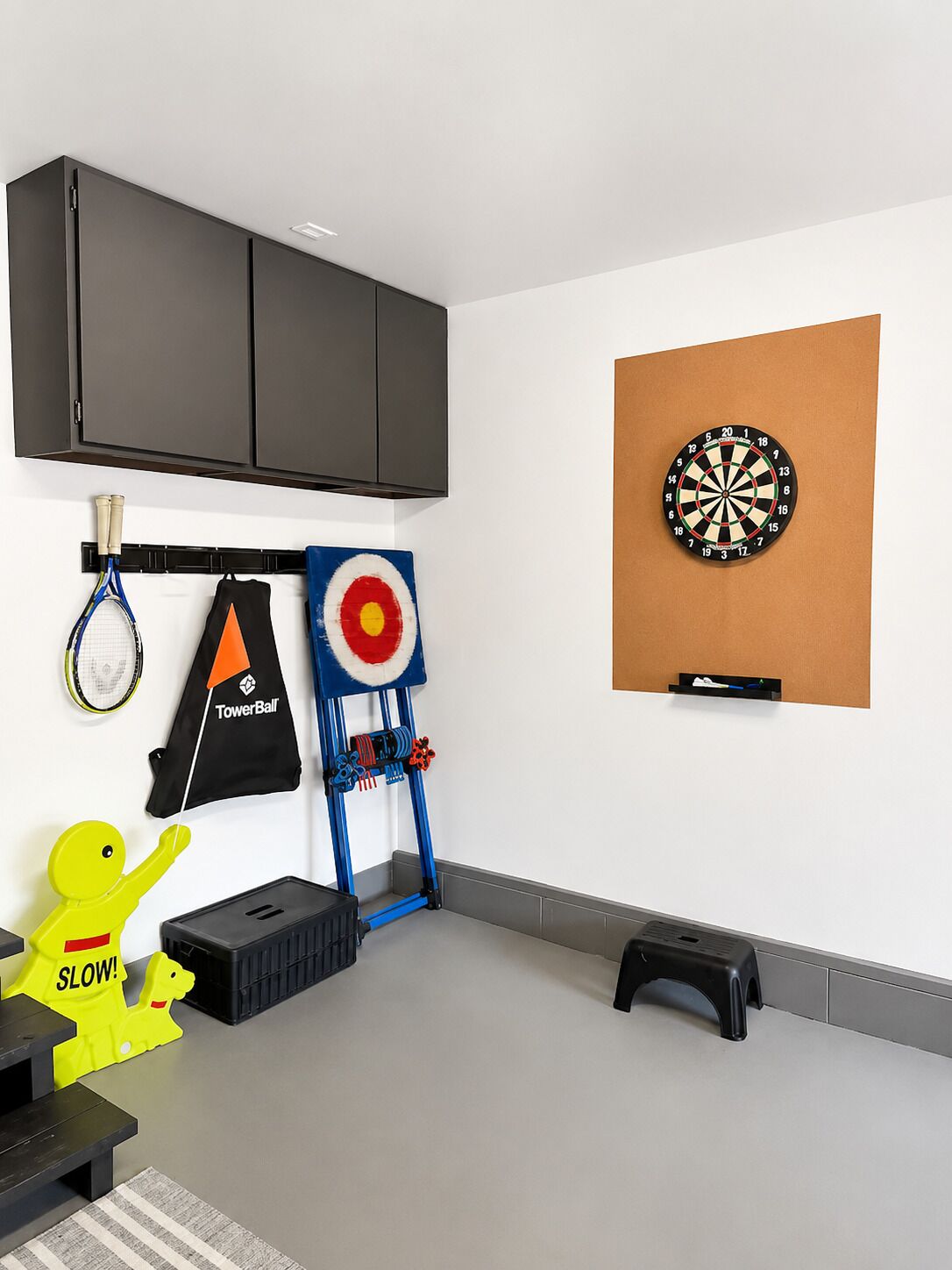 Una habitación con dardos, un objetivo y una figura de juguete.