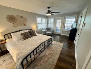 Cozy retreat with a large bed, ceiling fan, and window with blinds.