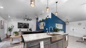 A modern kitchen with granite countertops, stainless steel appliances, and a blue accent wall. - Country Style Oasis! With cleared trails for walking or exploring (Polk City)