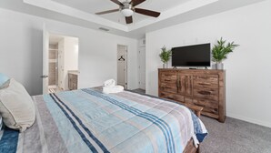 A bedroom with a bed, a ceiling fan, a wooden dresser, a TV, and a plant. - Country Style Oasis! With cleared trails for walking or exploring (Polk City)