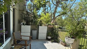 A patio with outdoor furniture, potted plants, and a view of the surrounding area. - Prestigous Location within LBUSD. Mid to Long Term Discounts. Views of Foothills (Aliso Viejo)