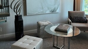 A living room with a large horse painting, a modern lamp, a glass coffee table, a white sofa, and a decorative metal sculpture. - Prestigous Location within LBUSD. Mid to Long Term Discounts. Views of Foothills (Aliso Viejo)