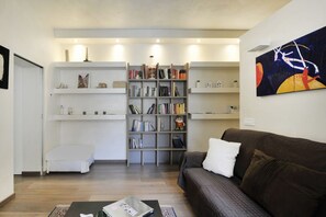 A modern living room with a bookshelf, a brown sofa, and a coffee table.