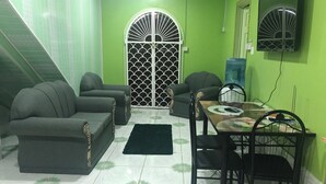 Uma sala de estar com sofá, cadeiras, uma mesa de jantar e um portão decorativo.