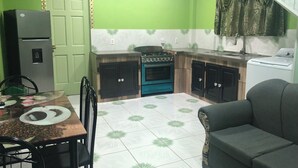 Uma cozinha compacta com geladeira, fogão, forno e máquina de lavar.