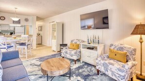 A living room with a round coffee table, two patterned armchairs, a side table, and a lamp. - Beach Condo. Across from Ocean Annie's. 1st floor beach condo with large pool. (Myrtle Beach)