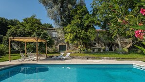 Ein Schwimmbecken mit Liegestühlen und einer Pergola.