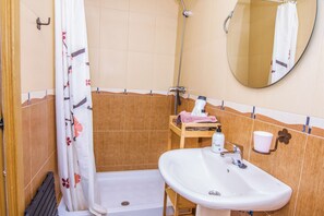 A bathroom with a shower, a sink, a mirror, and a towel rack. - Beach House Millares (Carboneras)