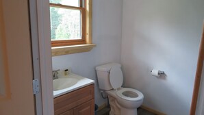 A small bathroom with a toilet, sink, and window. - Just 15 minutes from Ricketts Glen State Park, Restaurant and Bed & Breakfast  (Benton)