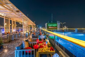 A rooftop bar with outdoor seating and a pool, featuring a neon sign for 'Canopy Rooftop Bar & Lounge'. - Hibiscus select hotel (Greater Noida)