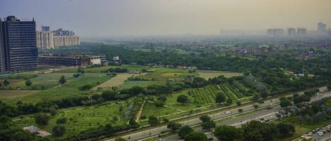 Un paysage urbain mêlant immeubles de grande hauteur et espaces verts, notamment un grand parc doté de sentiers et d’une aire de jeux.