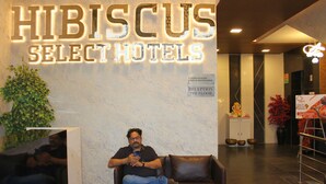 Un área de recepción con un cartel que dice 'Hibiscus Select Hotels' y un mostrador de recepción.