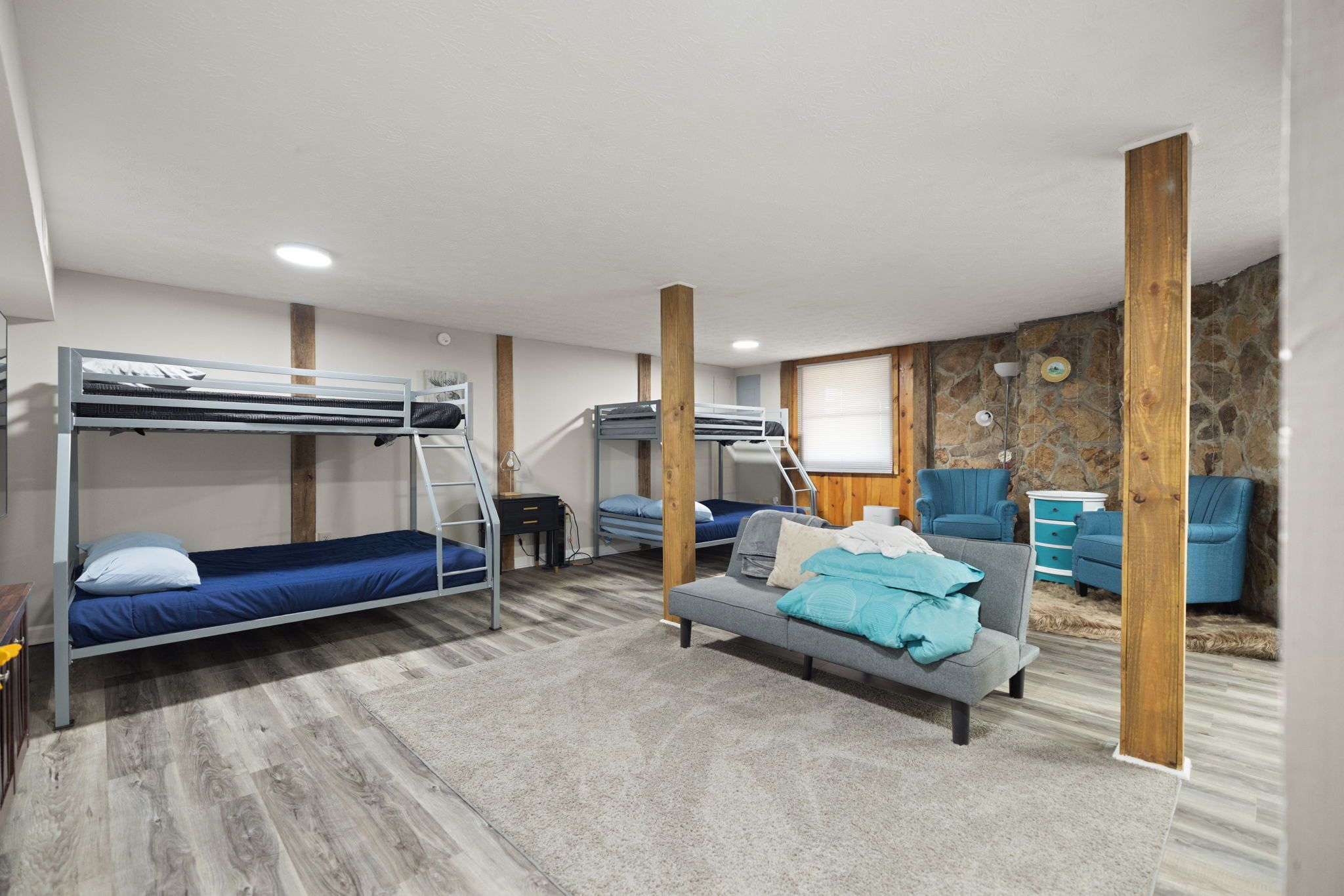 Une chambre avec des lits superposés, un canapé et un bureau.