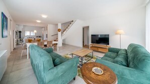 A spacious living area with a sofa, coffee table, and TV. - La Casa di Antonietta (Udine)