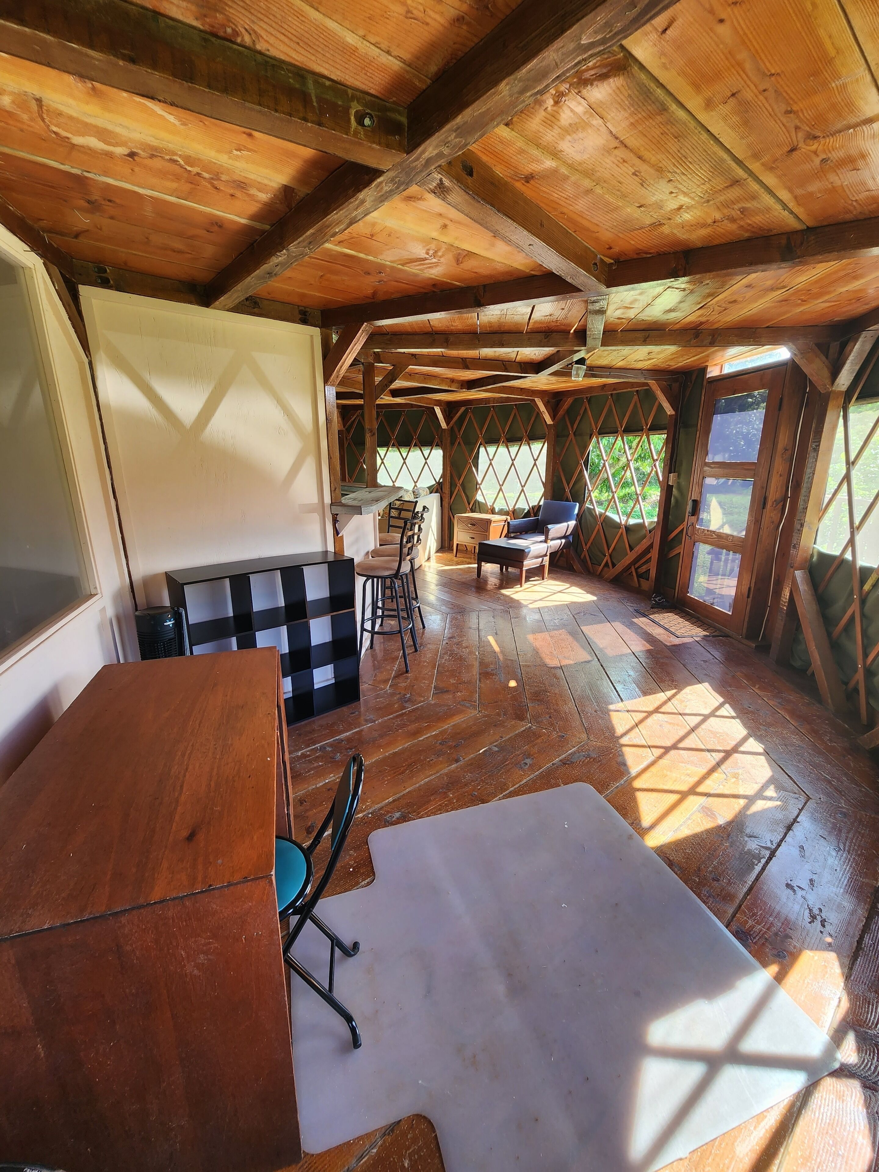 Una habitación rústica de madera con una mesa, un sofá y una silla.