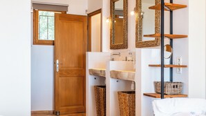 A bathroom with a wooden door, a sink with a stone countertop, and a mirror with a woven frame. - 5-Br. VILLA with sauna, swimming pool and sea view (La Roquette-sur-Siagne)