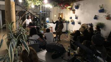 Evento al aire libre con un músico interpretando, rodeado de invitados sentados.