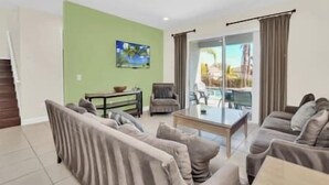 A living room with a sofa set, a coffee table, and a painting on the wall. - Swift BnB - Taylor themed rooms - Pool - sleeps 16 (Kissimmee)