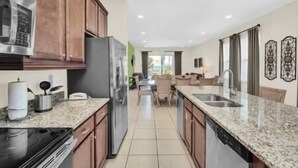 A modern kitchen with granite countertops, stainless steel appliances, and wooden cabinets. - Swift BnB - Taylor themed rooms - Pool - sleeps 16 (Kissimmee)