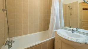 A bathroom with a bathtub, a shower, and a sink. - Près du centre & des pistes | Charmant T3 de 55m² (Orcières)