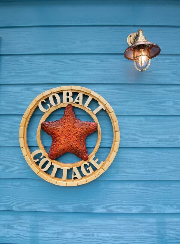 A wooden sign with 'Cobalt Cottage' and a starfish emblem on a blue wooden wall. - Ocean Front: rooftop deck, generator & more! (Upper Bogue)