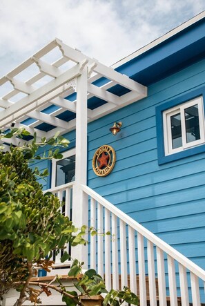 A blue house with a porch, a wooden fence, and a sign that reads 'Cottage.' - Ocean Front: rooftop deck, generator & more! (Upper Bogue)