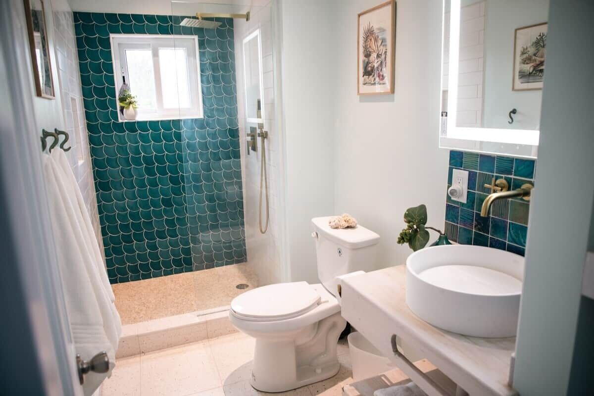 A bathroom with a white toilet, a sink, and a shower area.
