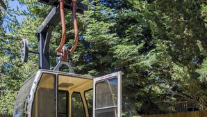 A cable car with an open door, a wooden fence, and a stone staircase in the foreground. - Tahoe Getaway | 2 King Suites & Hot Tub | Near Town, Lake Activities & Trails (Truckee)