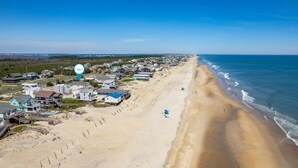 A coastal area with beachfront properties and a clear sky.
