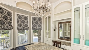 Una habitación amplia con una isla grande de mármol, un candelabro y vistas a través de una ventana con balcón.
