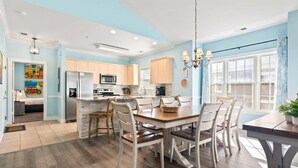 Une cuisine moderne avec un îlot central, un plancher en bois et des murs bleu clair.