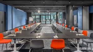 Une salle de conférence avec une longue table, des chaises et un projecteur.