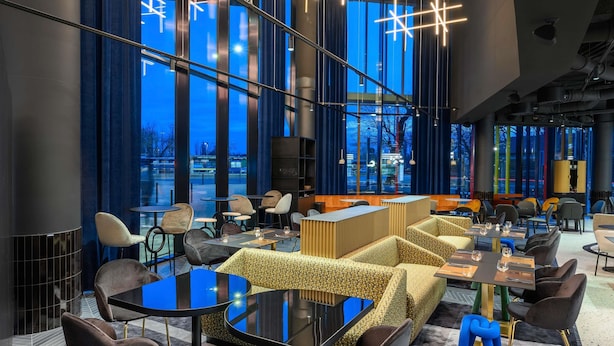 Un intérieur moderne avec de grandes fenêtres, un mobilier contemporain et un espace salon central.