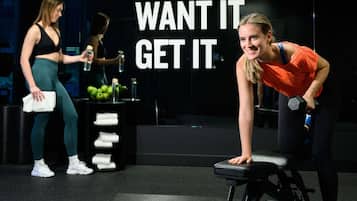 A gym with exercise equipment and motivational wall text.