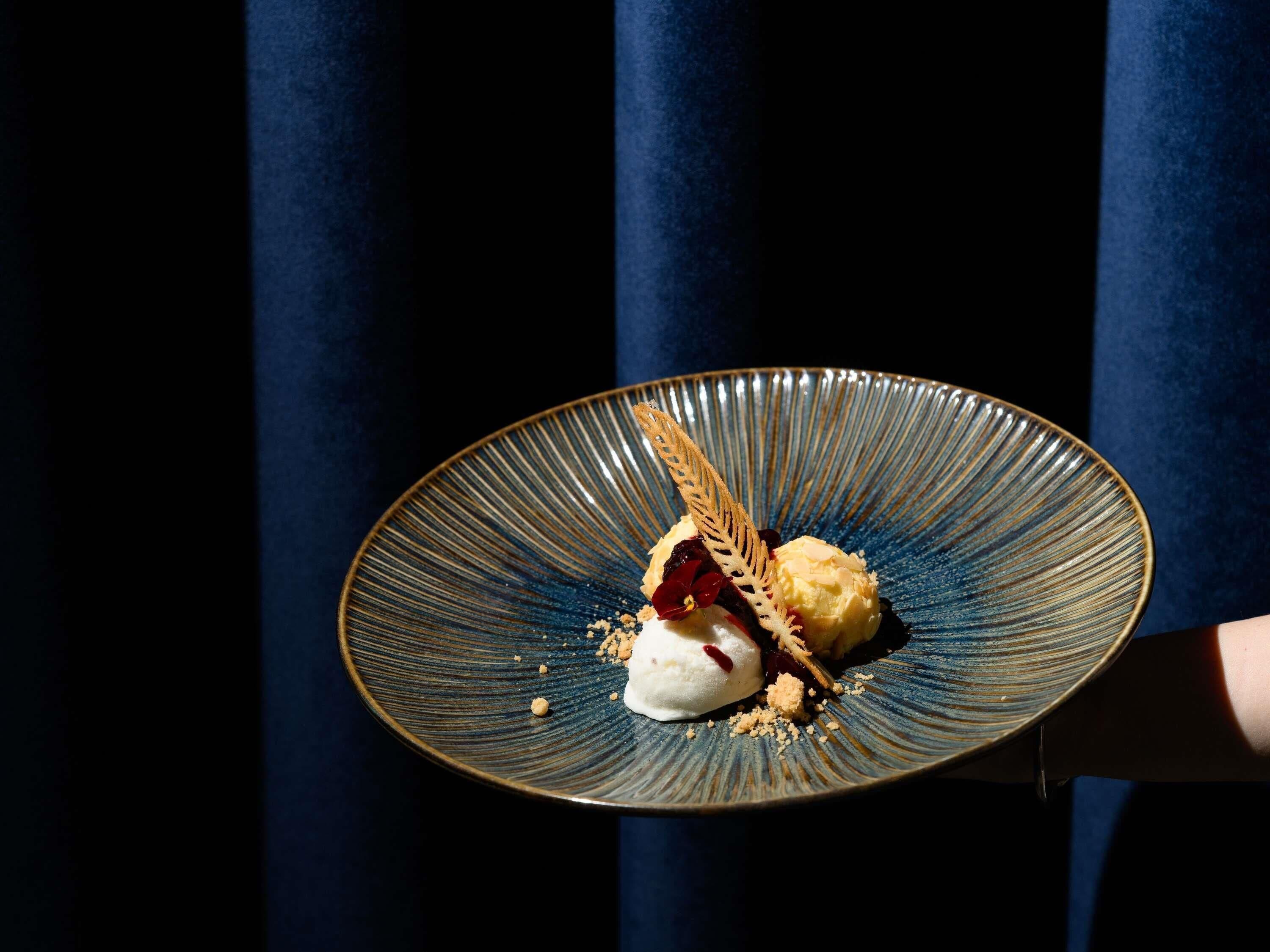 A dessert on a plate with a blue rim, held by a person.