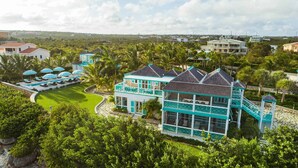 A large resort with a pool area, multiple guest rooms, and a well-maintained garden. - Charming waterfront Caribbean estate - 2 min from pink sand beach (Little Harbour)