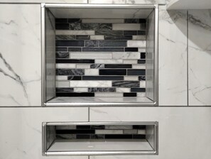 A bathroom with a tiled backsplash featuring a mix of black, white, and gray tiles.
