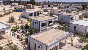 Ett modernt bostadsområde med kompakta, enplanshus som har stora fönster och platta tak.