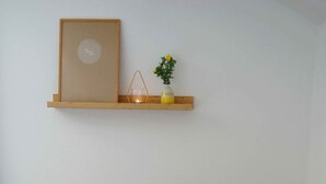 A bedroom with two beds, a bedside table with a lamp, and a shelf with a framed picture and a small plant. - Sun II für 1-4 Personen, 60 m², Schlafzimmer, Wohn/schlafzimmer, Küche, Bad, Balkon, Wlan (Marquartstein)