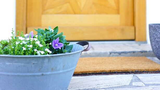 A metal bucket with flowers in front of a wooden door with a star pattern. - Sun II für 1-4 Personen, 60 m², Schlafzimmer, Wohn/schlafzimmer, Küche, Bad, Balkon, Wlan (Marquartstein)