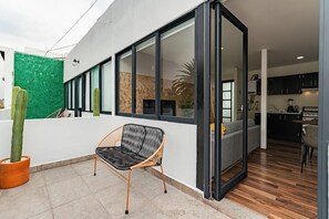 A modern interior with a dining area, kitchen, and a large sliding glass door leading to a balcony. - VH | Amazing Loft with Balcony | Narvarte | 34 (Ciudad de México)