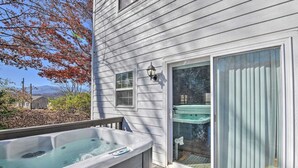 Una casa con jacuzzi, puerta corrediza de vidrio y terraza.
