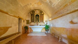 A chapel with a high arched ceiling, a central altar, and benches along the walls. - SON MAYOL 1 - Fantastic private apartment in agroturismo, with shared pool and free Wifi (Felanitx)