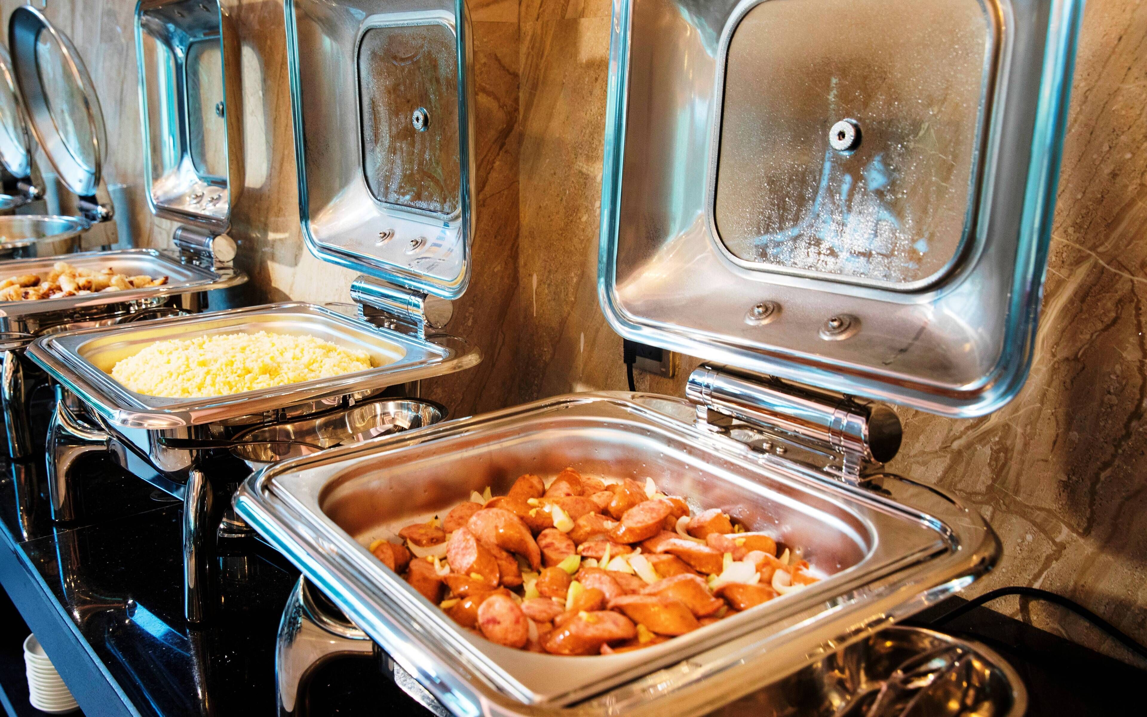 A buffet with various food items, including rice, sausages, and other dishes.