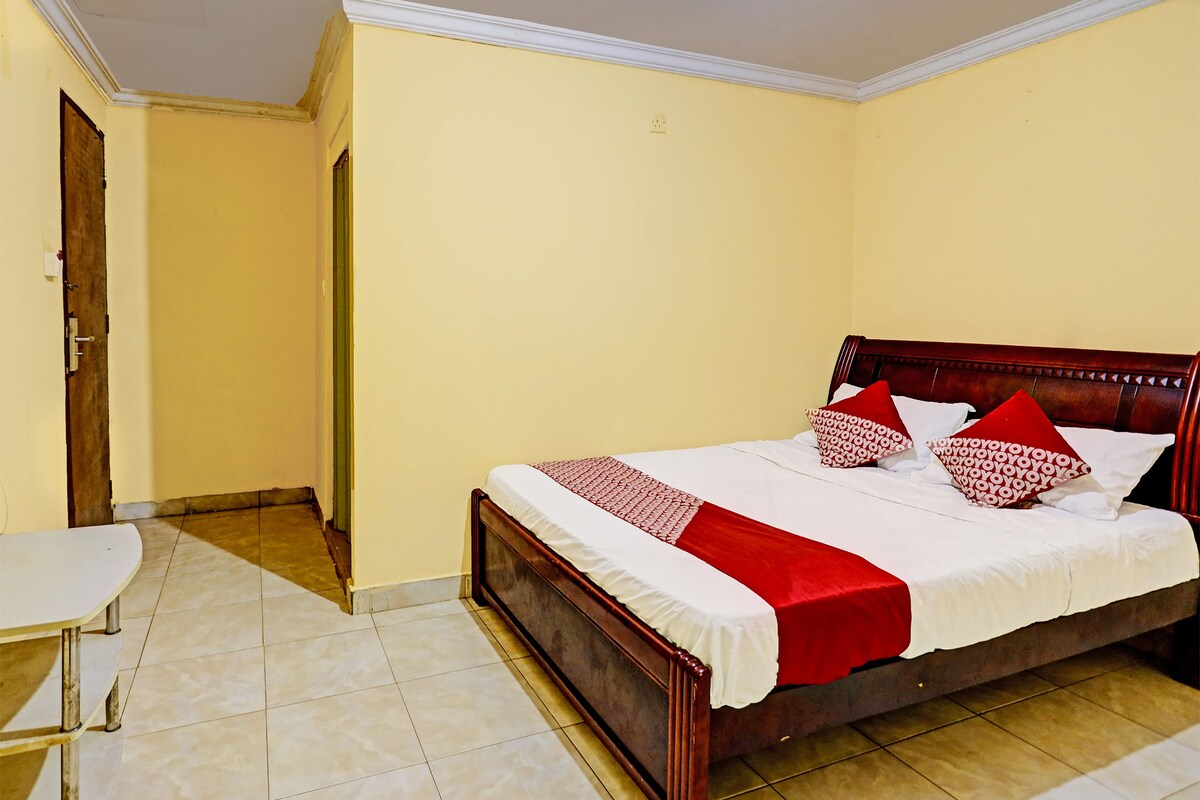 A bedroom with a bed, a chair, and a door.
